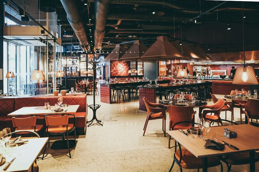 Interior de un restaurante con mesas servidas, listo para el servicio de la noche